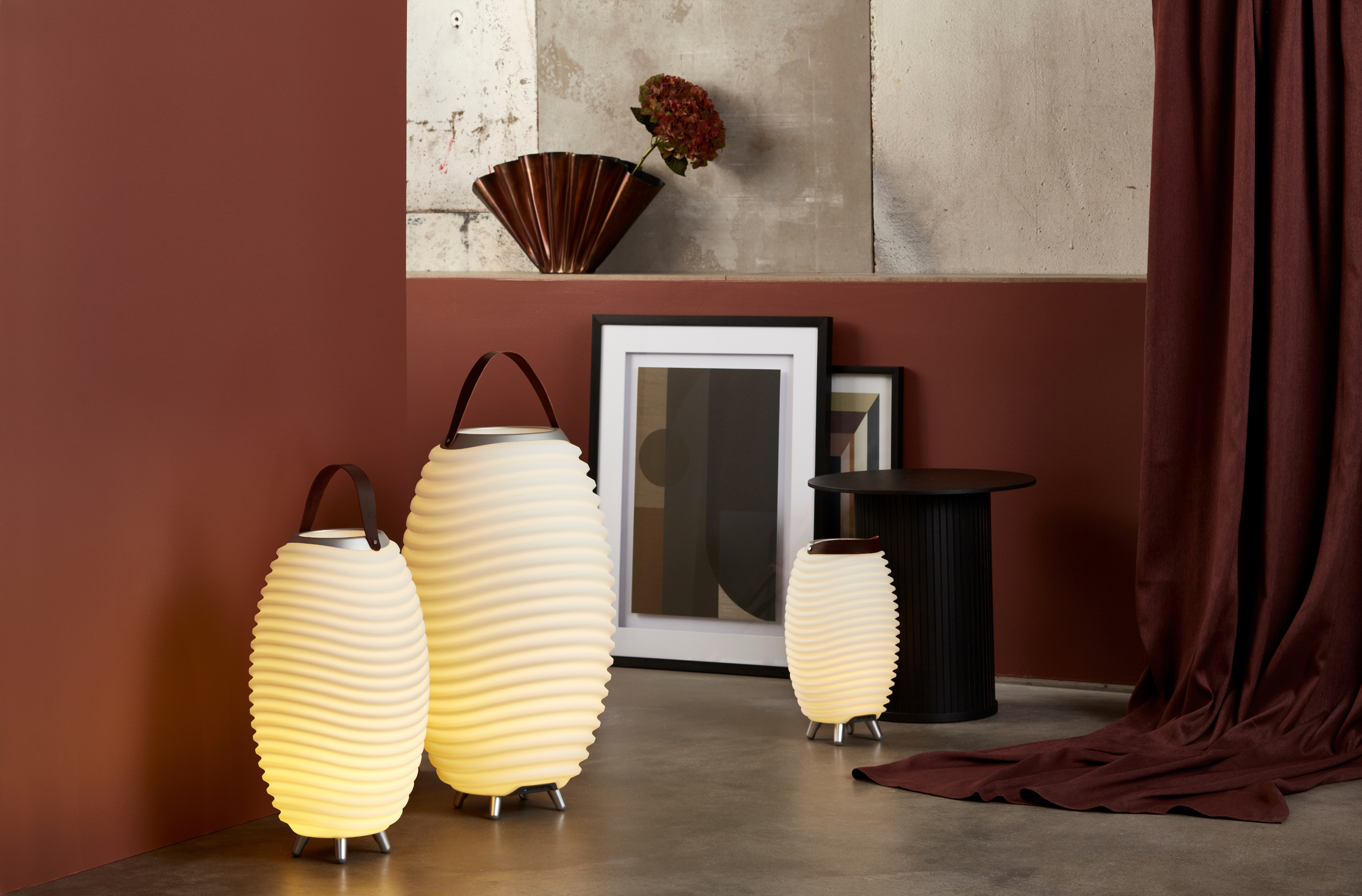 Kooduu Synergy tragbare Leuchten in Atelier mit roten Wänden und Sichtbeton