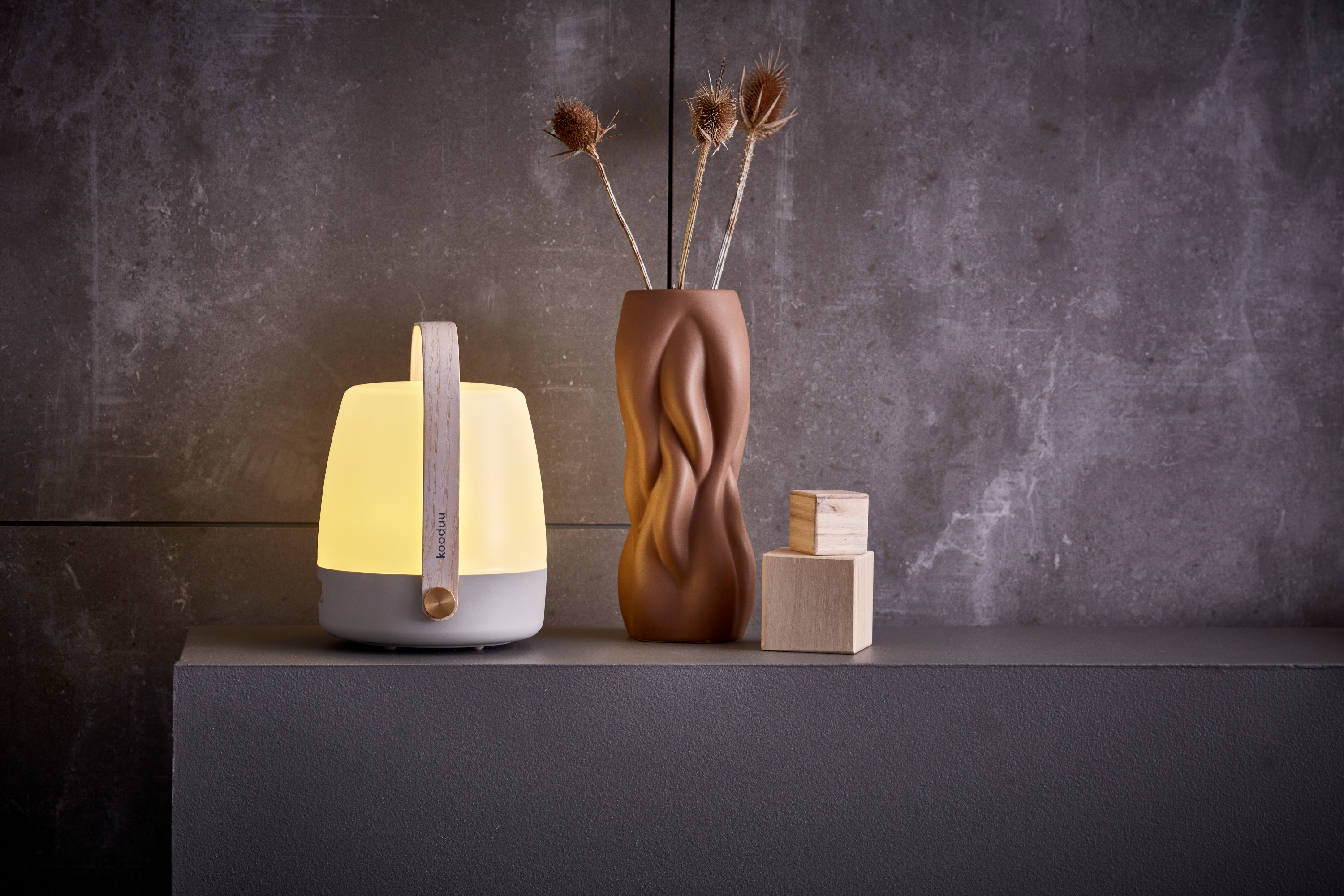 Kooduu Lite-up 2.0 tragbare Lampe mit Holzgriff auf Sideboard mit Designervase